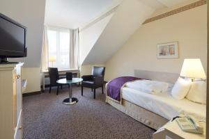 a hotel room with a bed and a tv at Best Western Hotel Helmstedt am Lappwald in Helmstedt