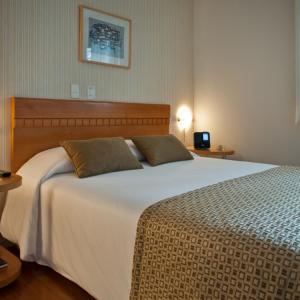 a hotel room with a bed and a television at Rio Hotel by Bourbon Curitiba Batel in Curitiba