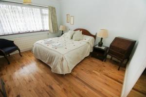 a bedroom with a bed and a dresser and a window at Dean Court Bungalow - Parking - by Brighton Holiday Lets in Rottingdean