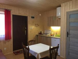 una cocina con mesa y una pequeña cocina con encimera en Ośrodek Słonecznik, en Hel