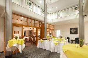 uma sala de jantar com mesas com toalha de mesa amarela em Best Western Hotel Helmstedt am Lappwald em Helmstedt