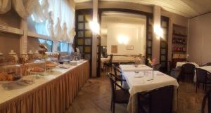 un restaurante con dos mesas con manteles blancos en Hotel Ariston en Acqui Terme