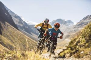 twee mensen die op een crossmotor een heuvel af rijden bij Heiners in Sölden