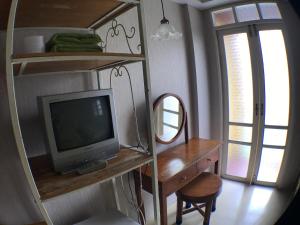 a room with a desk with a television and a desk with a chair at Roof View Place in Bangkok
