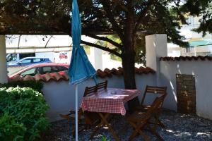a table with a blue umbrella and two chairs at Villa Verde Apartments and Rooms in Premantura