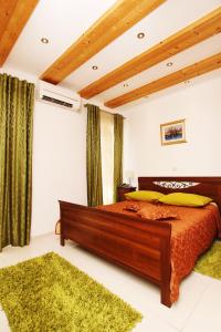 Villa Kampanel في تروغير: غرفة نوم بسرير وستائر خضراء