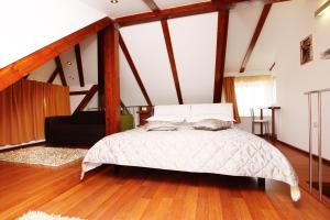 Villa Kampanel في تروغير: غرفة نوم بسرير في غرفة ذات أرضيات خشبية