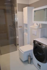 Un baño con inodoro y ducha de cristal. en Apartamenty Na Wydmie, en Ustka 48 fotos más