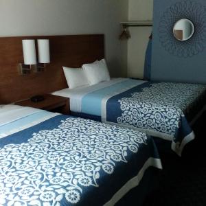 two beds in a room with a blue wall at Mainstreet Inn in Doylestown
