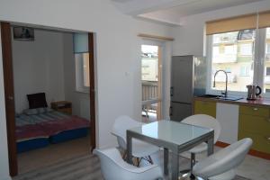 Una habitación con una mesa y sillas y un dormitorio. en Apartamenty Na Wydmie, en Ustka