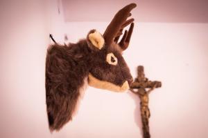 a stuffed moose head on a wall next to a cross at Zajček Apartma in Mojstrana