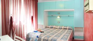 1 dormitorio con 1 cama en una habitación con paredes azules en Hotel Fortuna, en Caorle