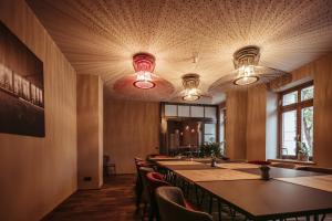 a conference room with tables and chairs and lights at alexxanders Hotel & Boardinghouse, Restaurant in Chemnitz