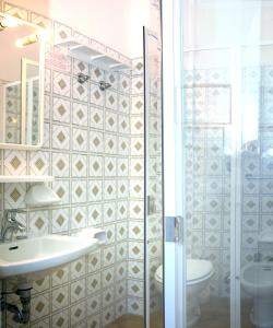 een badkamer met een douche, een wastafel en een toilet bij Hotel Fortuna in Caorle
