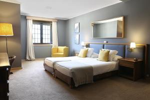 a bedroom with a large bed and a mirror at Cosy Sintra in Sintra