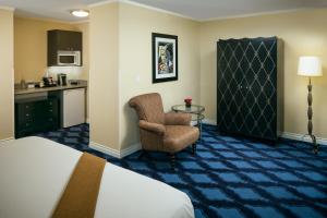 a hotel room with a bed and a chair at Plaza Inn & Suites at Ashland Creek in Ashland