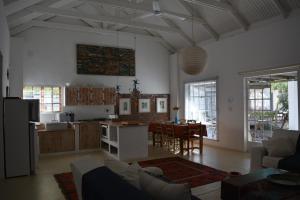 a living room with a kitchen and a dining room at Gecko Cottages in Prince Albert