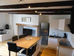 a kitchen with a wooden table and chairs in a room at le zola in Figeac