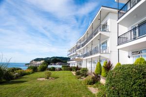 um edifício de apartamentos com um relvado em frente ao oceano em Ocean View Hotel em Shanklin