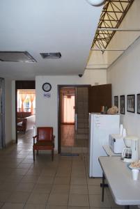 a kitchen with a refrigerator and a chair in a room at Hotel Centric Chihuahua in Chihuahua