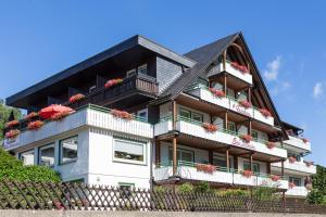 a large house with flowers on the balconies at Gästehaus Behle-Schäperken in Willingen