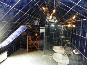 a bathroom with two sinks and a blue tiled ceiling at Dom Goscinny Andy in Pobierowo