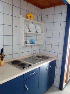 a kitchen with a sink and a blue tiled wall at Boutique Apartments Julija in Vodice