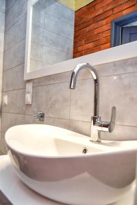 a white sink in a bathroom with a mirror at Baltic Lodge in Pobierowo