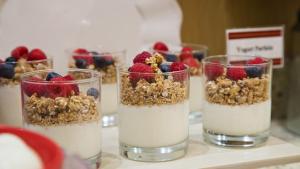 three glasses of yogurt with berries and granola on a table at The Florida Hotel & Conference Center in the Florida Mall in Orlando
