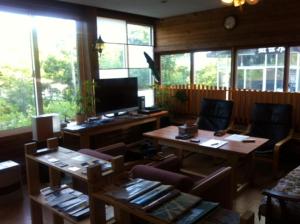 een woonkamer met tafels, stoelen en ramen bij Niseko Side 6 in Niseko