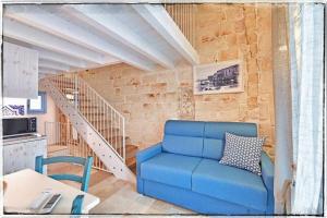 eine blaue Couch in einem Wohnzimmer mit einer Treppe in der Unterkunft Dimora Barone in Monopoli