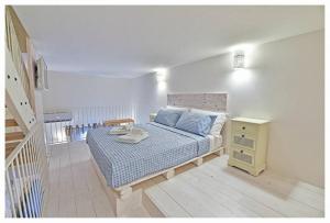 ein Schlafzimmer mit einem Bett mit blauer Bettwäsche und einem Nachttisch in der Unterkunft Dimora Barone in Monopoli