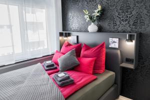 a bed with red pillows on it in a bedroom at Friedrich Boutique-Apartments in Freiburg im Breisgau