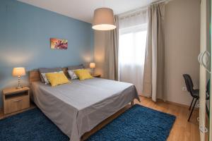 a bedroom with a large bed with yellow pillows at Apartments Sanjin in Kornić