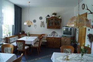 Pension Jagdhütte في سانكت أندرياسبرغ: غرفة طعام مع طاولات وكراسي وتلفزيون
