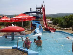 eine Gruppe von Personen in einem Pool in einem Wasserpark in der Unterkunft Apartments Sanjin in Kornić