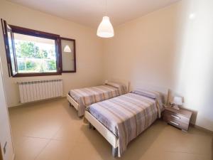 two beds in a room with a window at Nel Cuore Del Salento in San Donato di Lecce