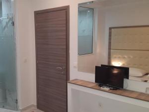 a bathroom with a television on a counter with a mirror at Hotel Rex in Thessaloniki