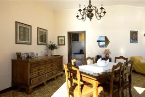 a dining room with a table and a room with a couch at Villa Camelia in Verbania