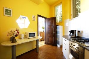 a kitchen with yellow walls and a counter with a microwave at Villa Camelia in Verbania +21 photos