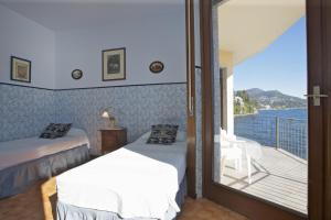a room with two beds and a balcony at Villa Camelia in Verbania