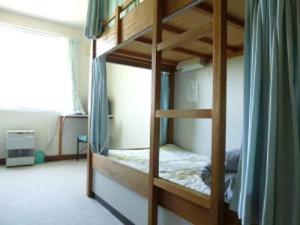 two bunk beds in a room with a window at Abashiri Ryuhyou no Oka guesthouse in Abashiri