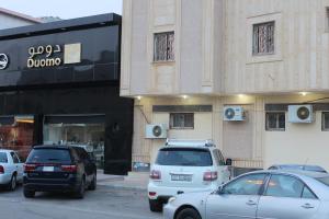 un grupo de autos estacionados frente a una tienda en Nozul Al Leqa Apartments, en Al Kharj