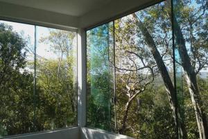 a room with two large windows with trees at Morada dos Elfos in Vale do Capao
