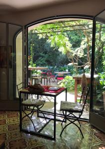 een kamer met een tafel en stoelen en een patio bij Les Jardins de Baracane in Avignon