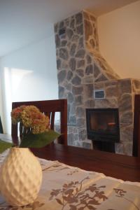 einen Steinkamin im Wohnzimmer mit einem Tisch in der Unterkunft Apartment Ajda in Bovec