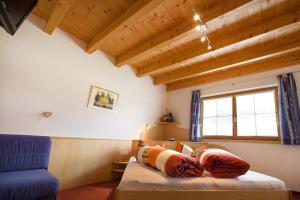 ナウダースにあるApart Alpenjuwelのベッドルーム1室(ベッド1台、青い椅子付)