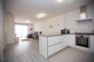 a kitchen with white cabinets and a living room at Altos del Mediterraneo La Zenia in Los Dolses