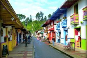 a group of people walking down a street with buildings at Mirador de los Cedros in Salento