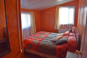 a bedroom with a bed and a window at Cabañas Patagonia Insitu in Puerto Natales